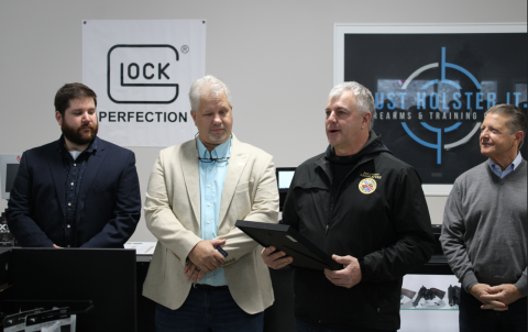 Legislator Malczewski presents a proclamation to the owners of Just Holster It