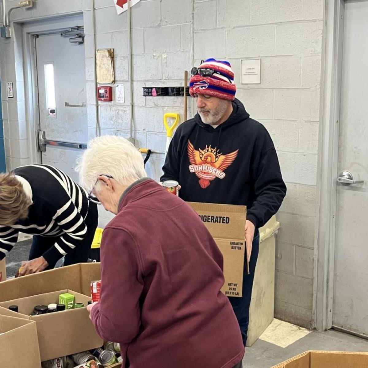 Erie County Legislator Chris Greene volunteers with FeedMore WNY, filling 20-pound boxes of non-perishable food for families in need
