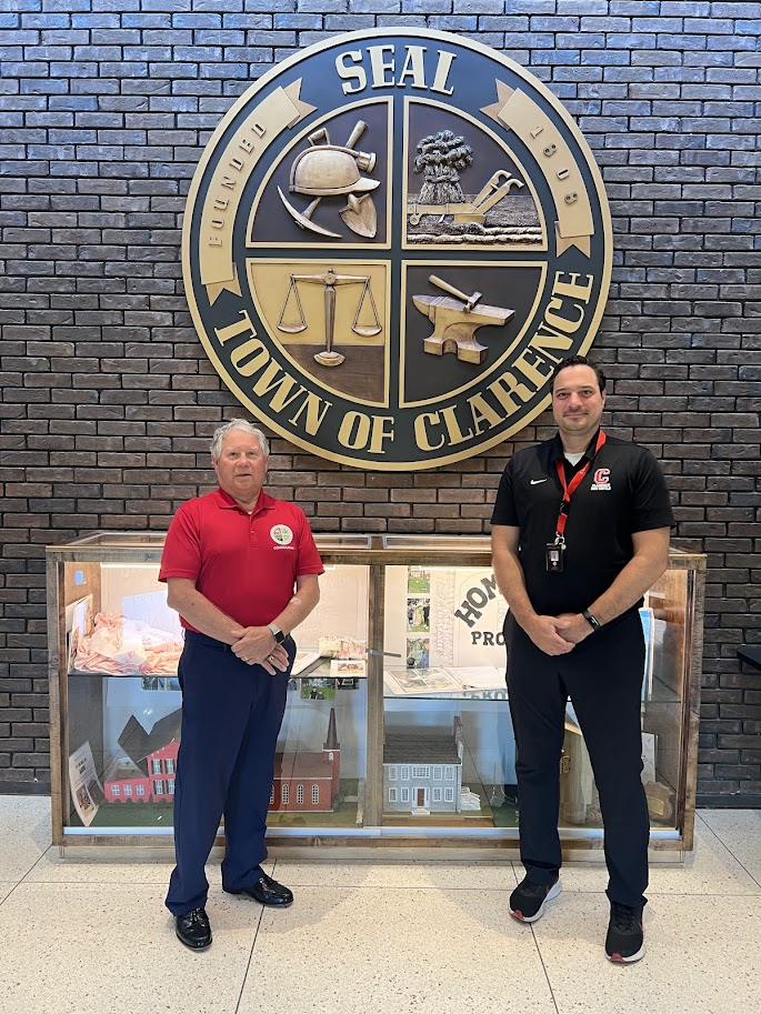 : Town Councilman Daniel Michnik (left) and Town Historian Joe McGreevy stand in front of the Clarence Town Seal.
