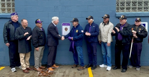 Erie County Clerk Mickey Kearns dedicates a reserved parking space for Purple Heart recipient service men and women at the Erie County Auto Bureau in Derby. On hand to assist in the unveiling was Purple Heart recipient James Trembath (center) of the Town of Evans, members of the Military Order of the Purple Heart, Chapter 187, and United States Air Force combat veteran and Town of Evans Councilman Mike Schraft (second from left).