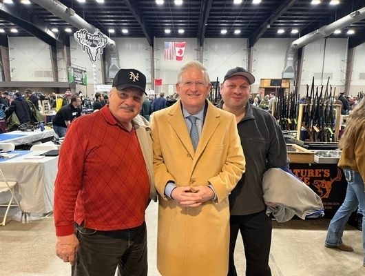 Clerk Mickey Kearns standing with two citizens at the NFG Shows Gun Show, providing support for legal firearm registration and responsible ownership.
